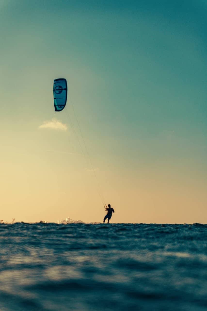 Kitesurfista navegando ao pôr do sol na Ilha do Guajirú