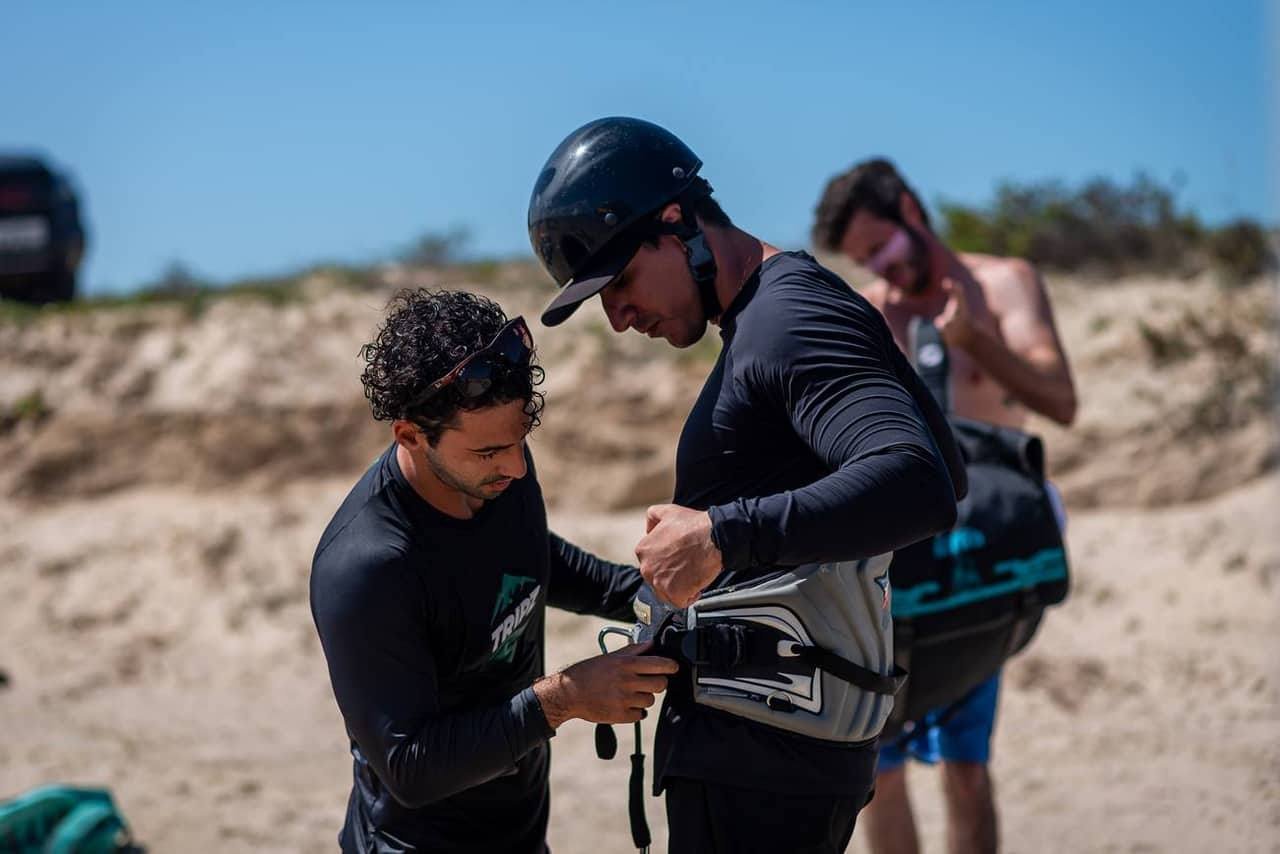 Instrutores preparando o equipamento de kitesurf na praia