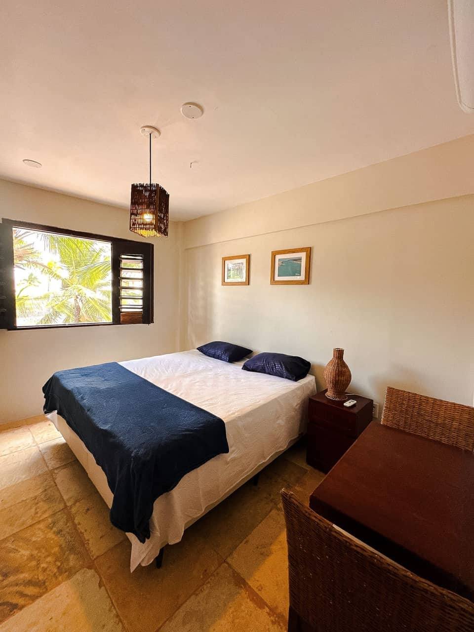 Quarto de casal com cama ampla e decoração clara