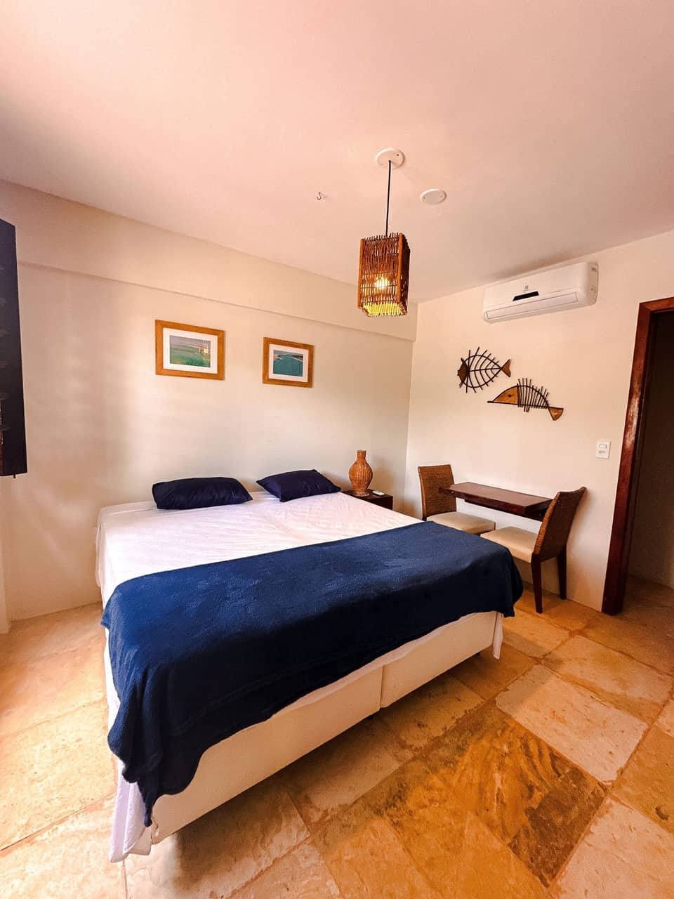 Quarto confortável com roupa de cama branca